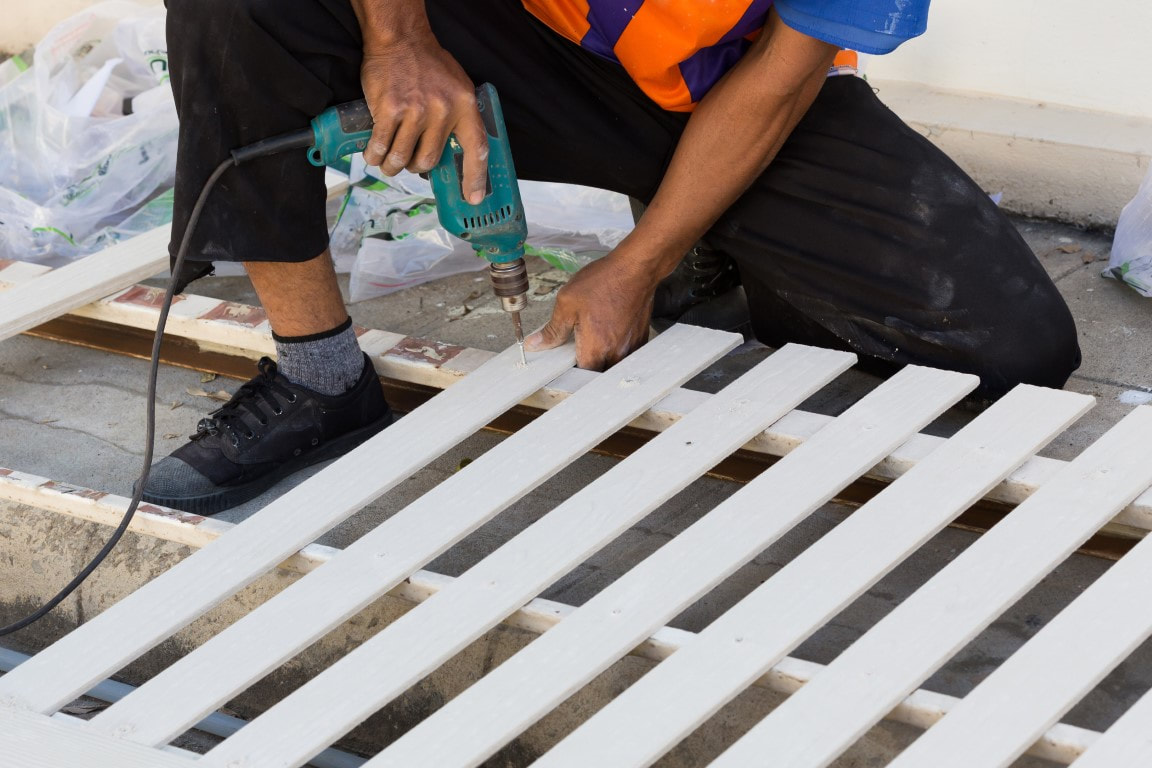 An image of a person working on a driveway fence installation service